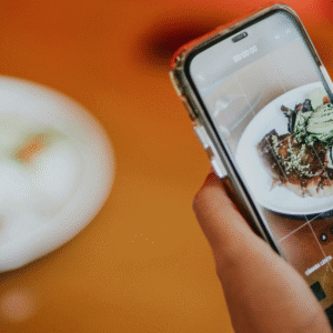Person filming a plate of food on a smartphone for a TikTok video, highlighting the rise of food trends on social media.