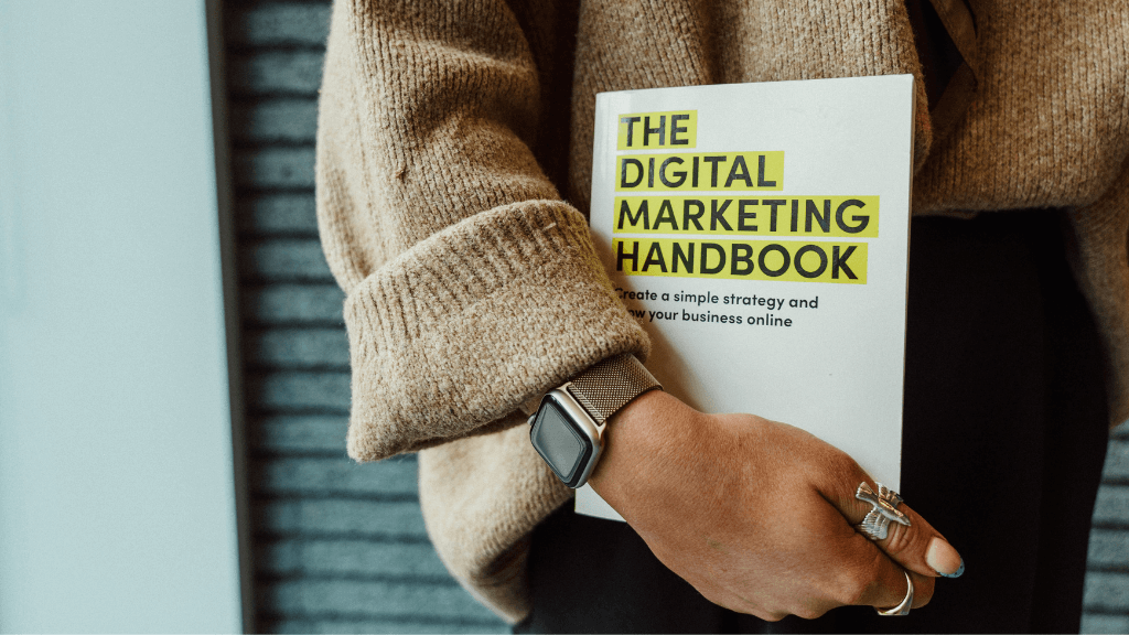 Person holding The Digital Marketing Handbook book, representing marketing strategy and growth for food and drink brands